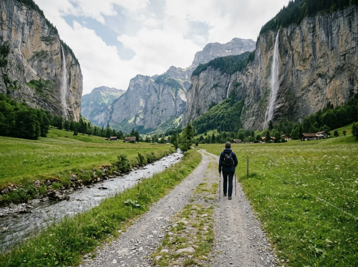 A flat gravel path along the Lauterbrunnen valley floor between waterfall-streaked cliffs, Switzerland