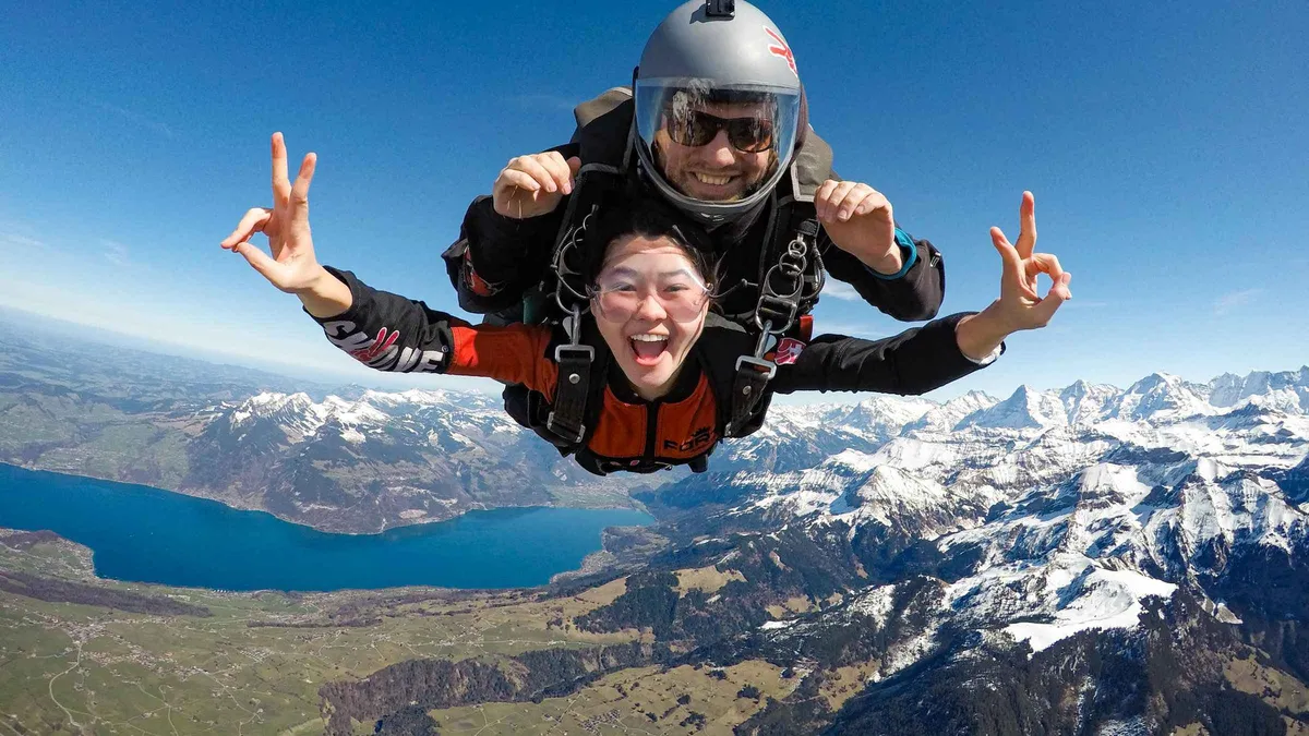 Tandem skydivers freefalling above the Swiss Alps near the Lauterbrunnen valley