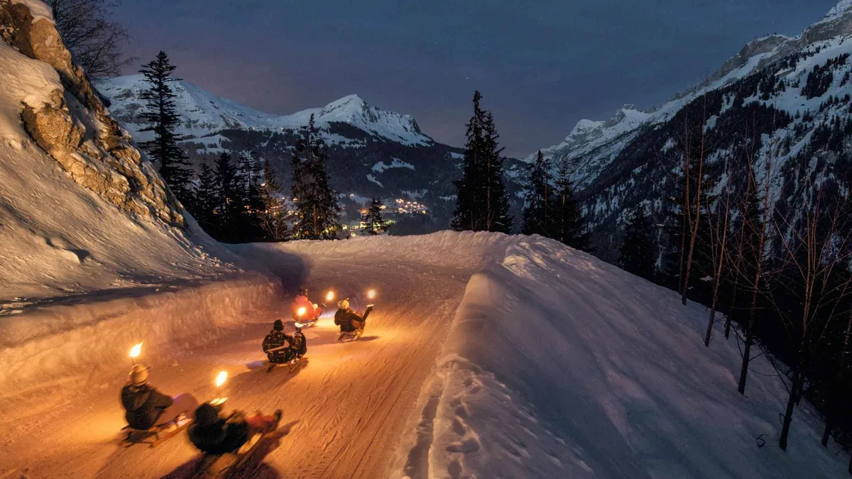 Sledder descending a snowy run above Interlaken at sunset near the Lauterbrunnen valley