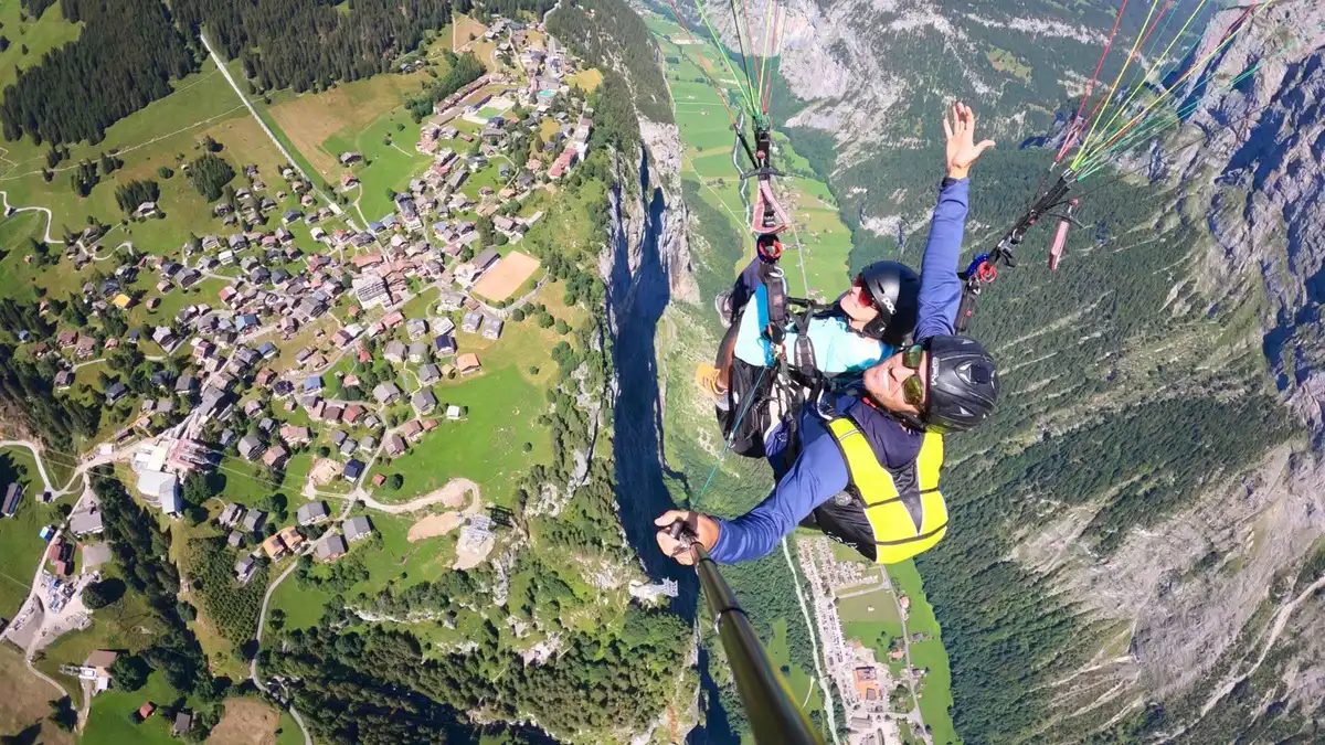 Paraglider pilot and passenger launching from Birg above the Lauterbrunnen valley near Mürren