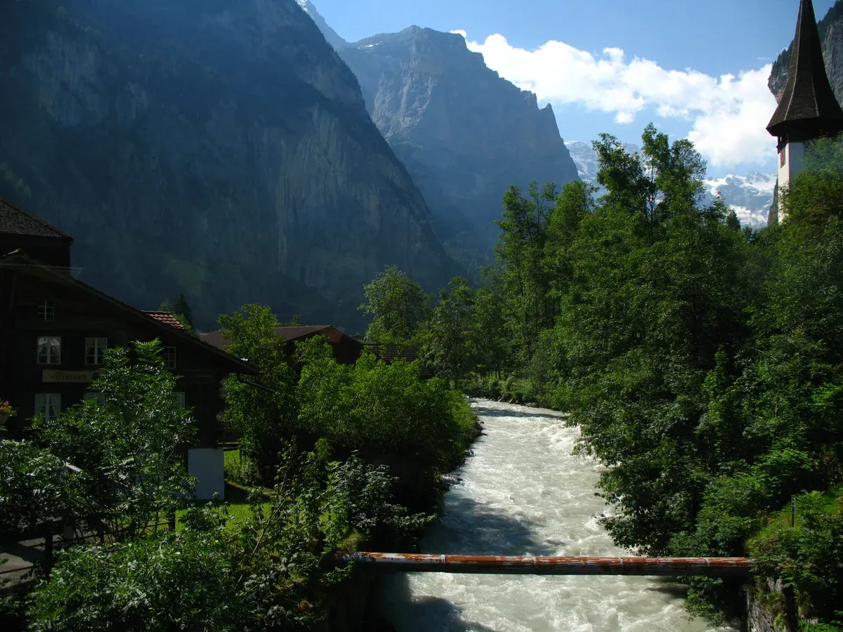 The White Luetschine river running through Lauterbrunnen village on the flat valley-floor route an e-bike ride follows from Interlaken into the Lauterbrunnen valley, Switzerland