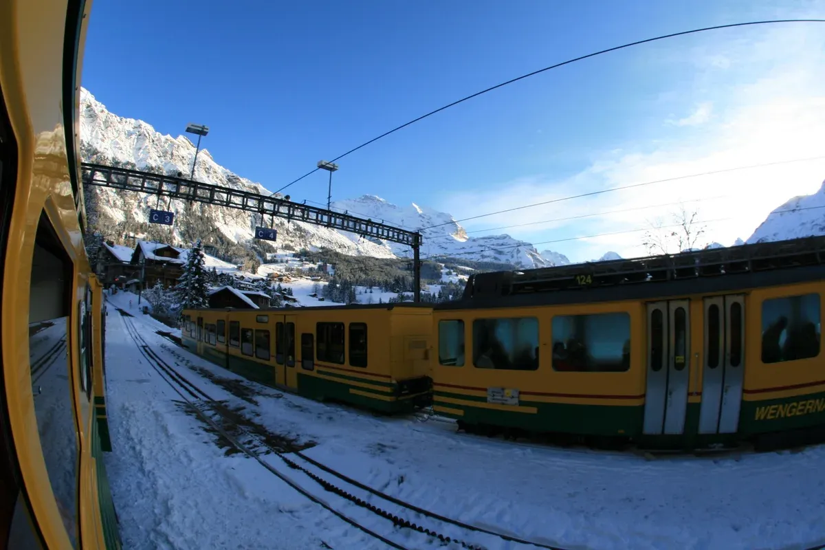 A Wengernalpbahn rack train climbing toward Wengen above the Lauterbrunnen valley
